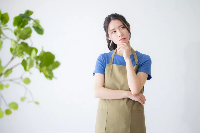 考えるエプロンの女性